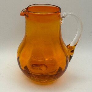 Unbranded hand blown orange with clear handle 3.5” miniature glass pitcher